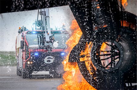 regulate - Fire engine spraying water on simulated fire at airport training facility Stock Photo - Premium Royalty-Free, Code: 649-07905588