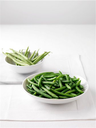 Raw green beans in bowl on cutting board and bowl of boiled green beans Stockbilder - Premium RF Lizenzfrei, Bildnummer: 649-07905620