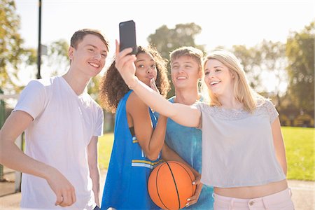 di adolescente - Four young adult basketball players taking smartphone selfie Fotografie stock - Premium Royalty-Free, Codice: 649-07905655