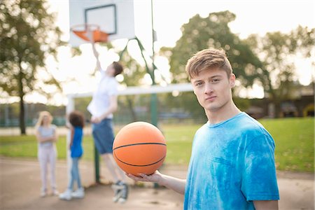 portraits of adolescent girls - Portrait of young male basketball player holding basketball Stock Photo - Premium Royalty-Free, Code: 649-07905679