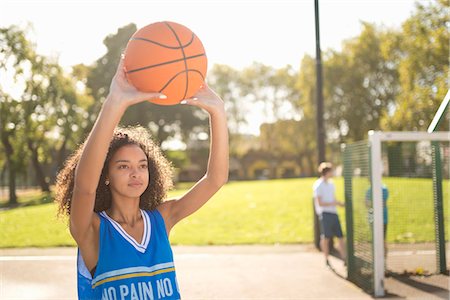 Young female basketball player holding up basketball Foto de stock - Royalty Free Premium, Número: 649-07905684