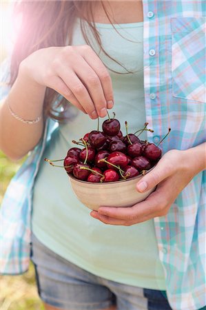 simsearch:614-08202342,k - Close up of young woman with bowl of cherries Stock Photo - Premium Royalty-Free, Code: 649-07905735