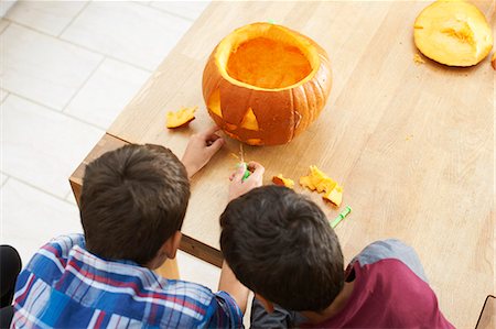 Siblings carving pumpkin in dining room Foto de stock - Sin royalties Premium, Código: 649-08004041