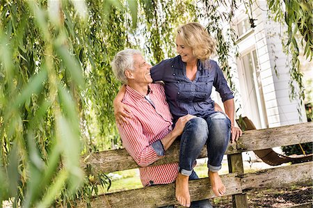 Husband carrying wife onto garden fence Stock Photo - Premium Royalty-Free, Code: 649-08004109