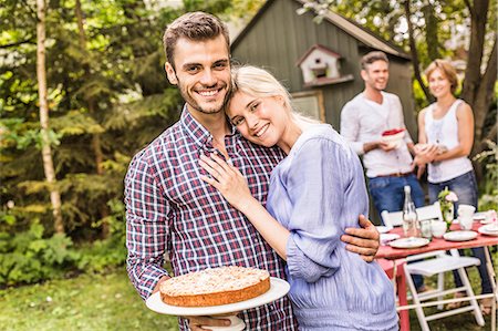 Group of friends at garden party, young man holding cake Stock Photo - Premium Royalty-Free, Code: 649-08004176