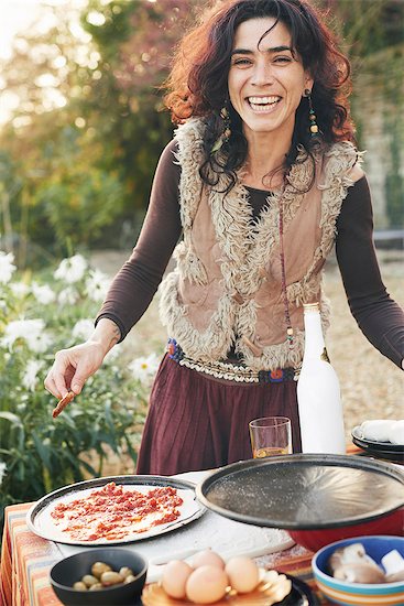 Portrait of mature hippy female preparing pizza in garden Stock Photo - Premium Royalty-Free, Image code: 649-08004225