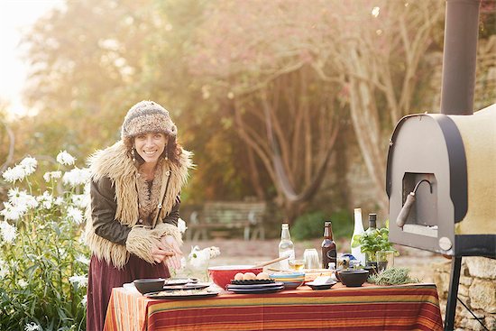 Mature hippy female preparing food on garden table Stock Photo - Premium Royalty-Free, Image code: 649-08004229