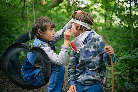 pintura facial - Boy face painting friend whilst playing in forest Foto de stock - Sin royalties Premium, Código: 649-08004277