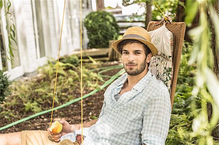 Young man sitting on hammock in garden Stock Photo - Premium Royalty-Free, Code: 649-08004345