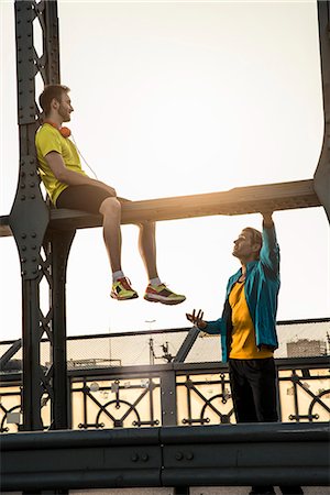 sitting in sport shorts - Friends relaxing on bridge, Munich, Bavaria, Germany Stock Photo - Premium Royalty-Free, Code: 649-08003981