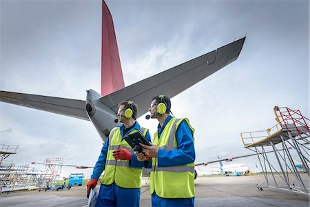 Airside engineers inspecting jet aircraft on runway Photographie de stock - Premium Libres de Droits, Code: 649-08060072