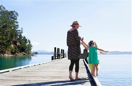 Mid adult woman and daughters playing on pier, New Zealand Foto de stock - Sin royalties Premium, Código: 649-08060153