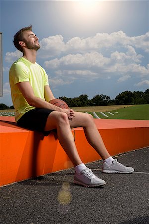 simsearch:649-07520889,k - Young male basketball player sitting on wall taking a break Fotografie stock - Premium Royalty-Free, Codice: 649-08060421