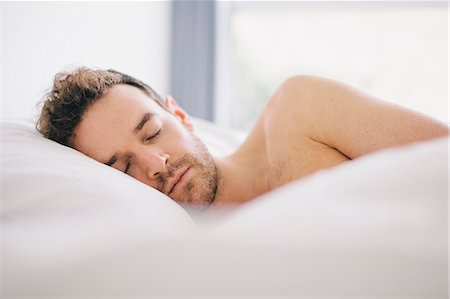 da solo - Young man lying on side asleep in bed Fotografie stock - Premium Royalty-Free, Codice: 649-08060604