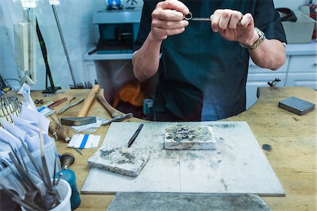 Cropped shot of jewellery craftsman filing platinum ring Fotografie stock - Premium Royalty-Free, Codice: 649-08060759