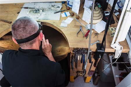 Overhead view of jewellery craftsman at workbench Stock Photo - Premium Royalty-Free, Code: 649-08060760