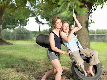 simsearch:649-08923581,k - Teenage girl pushing her sister on tire swing Stock Photo - Premium Royalty-Free, Code: 649-08060874