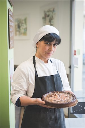 Baker carrying cake in cafe Photographie de stock - Premium Libres de Droits, Code: 649-08084561