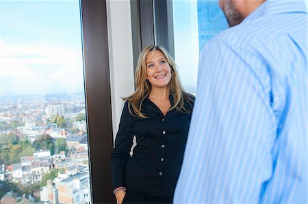 simsearch:649-08084743,k - Businessman and woman chatting in skyscraper office, Brussels, Belgium Photographie de stock - Premium Libres de Droits, Code: 649-08084744