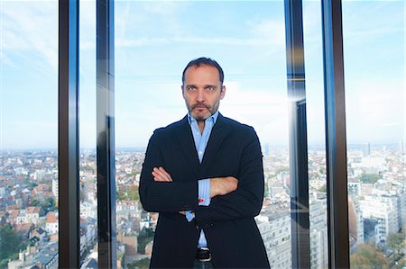 simsearch:614-08081431,k - Portrait of confident businessman in front of office window with Brussels cityscape, Belgium Stock Photo - Premium Royalty-Free, Code: 649-08084745