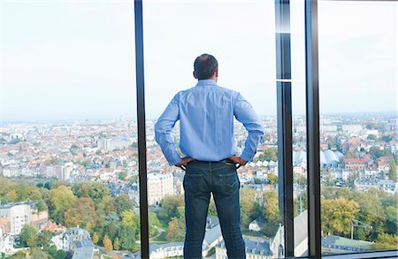 simsearch:649-08084743,k - Rear view of businessman looking from office window at Brussels cityscape, Belgium Photographie de stock - Premium Libres de Droits, Code: 649-08084748