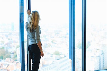 elevated view of a confident businesswoman - Mature businesswoman looking from office window at Brussels cityscape, Belgium Stock Photo - Premium Royalty-Free, Code: 649-08084758
