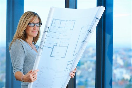 Mature female architect looking at plans in skyscraper office, Brussels, Belgium Stock Photo - Premium Royalty-Free, Code: 649-08084753