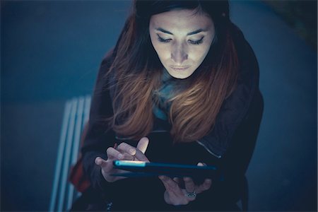 Mid adult woman using digital tablet touchscreen on railway platform at dusk Stock Photo - Premium Royalty-Free, Code: 649-08084945