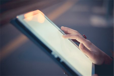 Hand of woman using digital tablet touchscreen at dusk Photographie de stock - Premium Libres de Droits, Code: 649-08084942