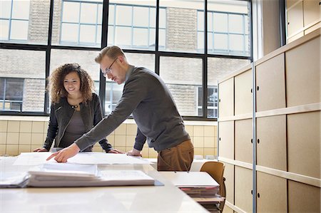 focus, determination - Young design team looking at blueprint in creative office Photographie de stock - Premium Libres de Droits, Code: 649-08084996