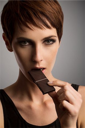 simsearch:6113-07147524,k - Studio portrait of woman eating dark chocolate Stock Photo - Premium Royalty-Free, Code: 649-08085094