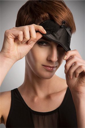 simsearch:614-08874246,k - Studio portrait of woman peeking from black eye mask Stockbilder - Premium RF Lizenzfrei, Bildnummer: 649-08085099
