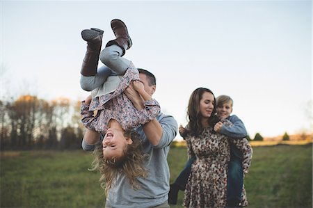 Young couple carrying son and daughter in field Stock Photo - Premium Royalty-Free, Code: 649-08085158