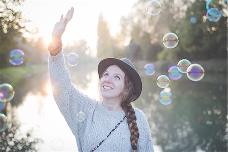 Young woman playing with bubbles Stock Photo - Premium Royalty-Free, Code: 649-08085383