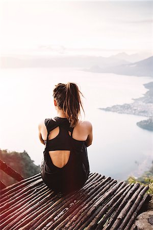 Rear view of young woman on balcony looking out over Lake Atitlan, Guatemala Fotografie stock - Premium Royalty-Free, Codice: 649-08085498