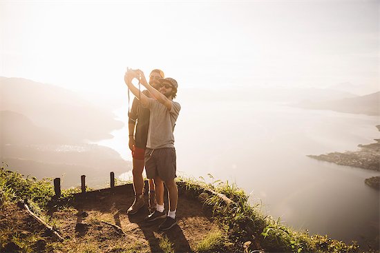 Two young men taking selfie at Lake Atitlan on digital camera, Guatemala Stock Photo - Premium Royalty-Free, Image code: 649-08085491