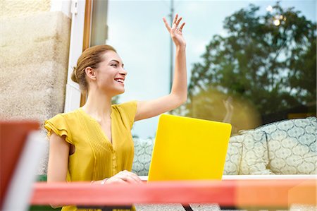 people and color dressing - Young woman signalling to waiter, using laptop outside cafe Photographie de stock - Premium Libres de Droits, Code: 649-08085579