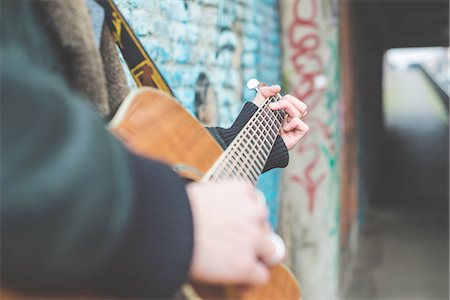 Musician playing guitar by canal wall, Milan, Italy Stock Photo - Premium Royalty-Free, Code: 649-08085891