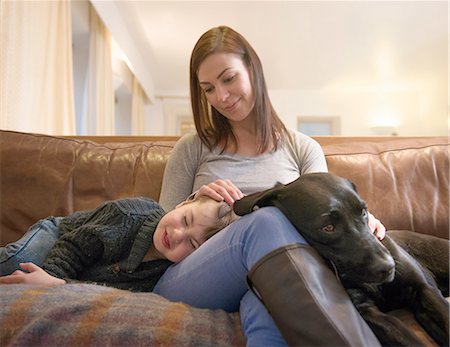 simsearch:649-08085438,k - Mother and tired son relaxing on sofa at home with pet labrador Stock Photo - Premium Royalty-Free, Code: 649-08085998