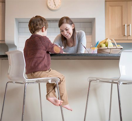 simsearch:649-08085434,k - Boy sitting on stool with mother in kitchen and drawing Foto de stock - Sin royalties Premium, Código: 649-08085993