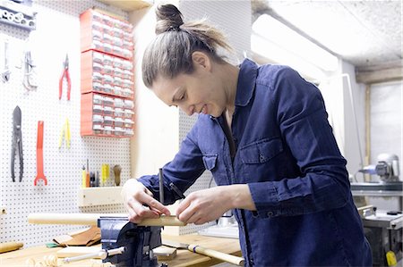 female artisan - Young female carpenter measuring timber in workshop vice Stock Photo - Premium Royalty-Free, Code: 649-08086057