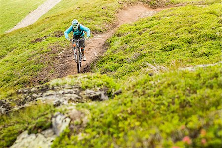 simsearch:649-07560113,k - Young female mountain biker cycling up hillside track Photographie de stock - Premium Libres de Droits, Code: 649-08086067
