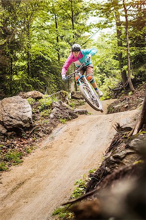 Young female mountain biker jumping mid air in forest Photographie de stock - Premium Libres de Droits, Code: 649-08086079