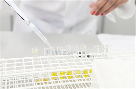 Female hand pipetting yellow liquid into test tubes in lab Stock Photo - Premium Royalty-Free, Code: 649-08086117