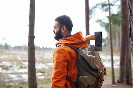 fir tree - Young man carrying axe looking out from forest Stock Photo - Premium Royalty-Free, Code: 649-08086308