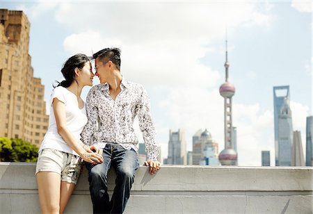 Romantic tourist couple sitting on wall, The Bund, Shanghai, China Stock Photo - Premium Royalty-Free, Code: 649-08086343