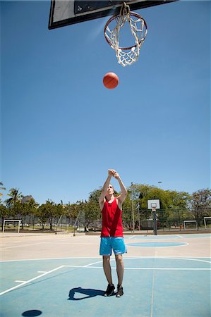 simsearch:649-09182176,k - Young male basketball player throwing ball toward basketball hoop Fotografie stock - Premium Royalty-Free, Codice: 649-08086354