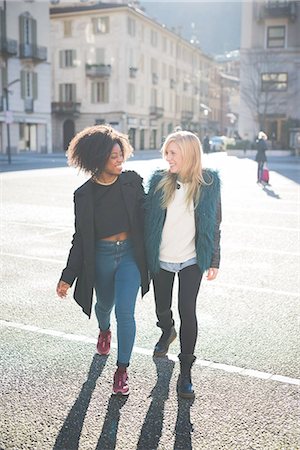 funky adults full body - Two female friends chatting and strolling in town square Stock Photo - Premium Royalty-Free, Code: 649-08086399