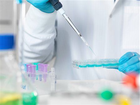 pharmaceutical research - Scientist pipetting sample into multi well tray for analytical testing in laboratory Stock Photo - Premium Royalty-Free, Code: 649-08086435