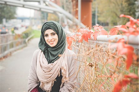 Portrait of young woman leaning against fence on park path Foto de stock - Sin royalties Premium, Código: 649-08086478